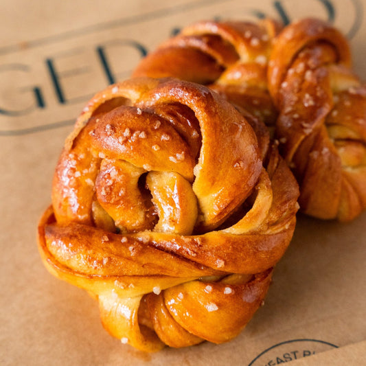 Close-up of a homemade Gerard bakery cinnamon roll pastry with a glossy finish and soft layers.
