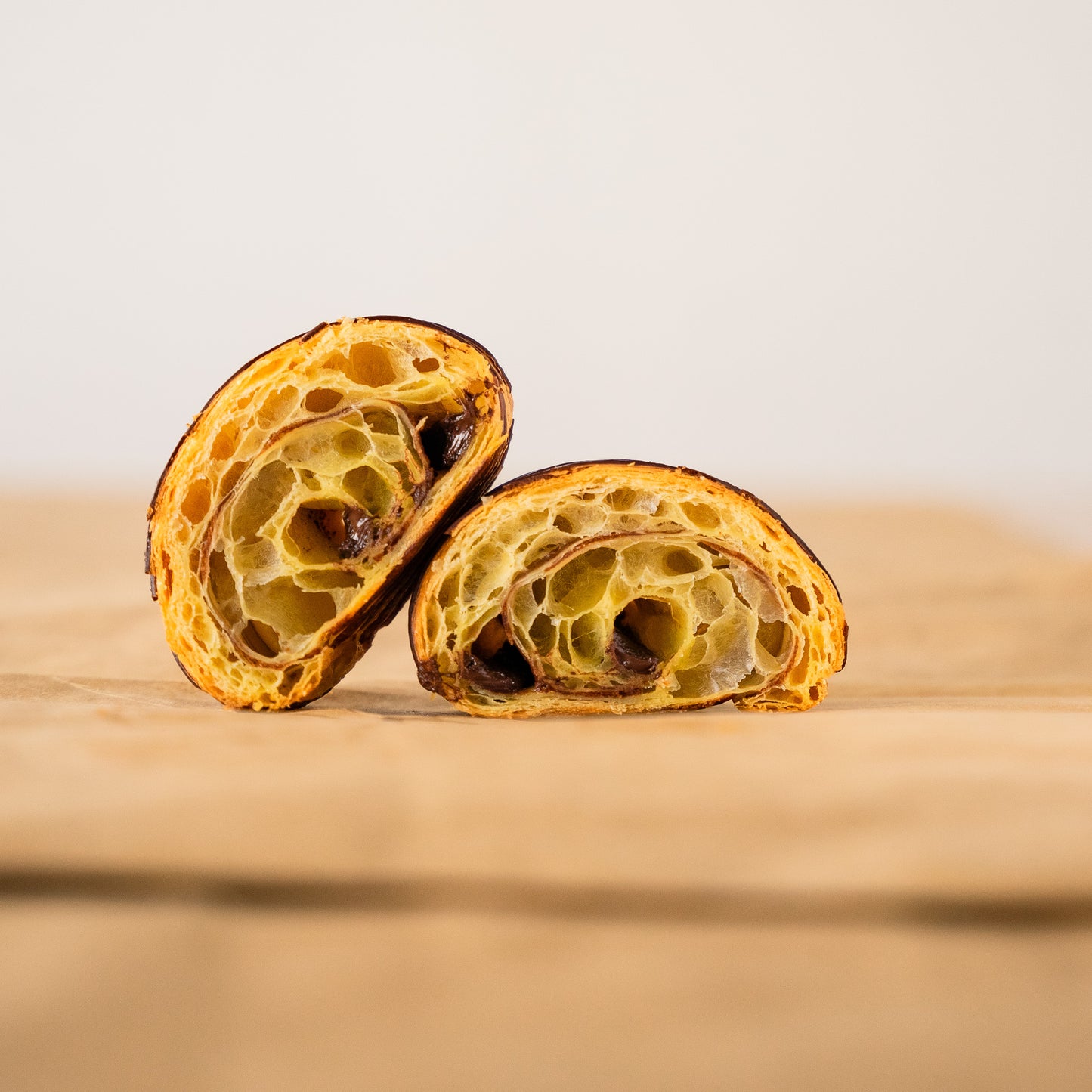 A chocolate bread that has been cut in half, revealing its delicious layers with chocolate inside and enticing texture.