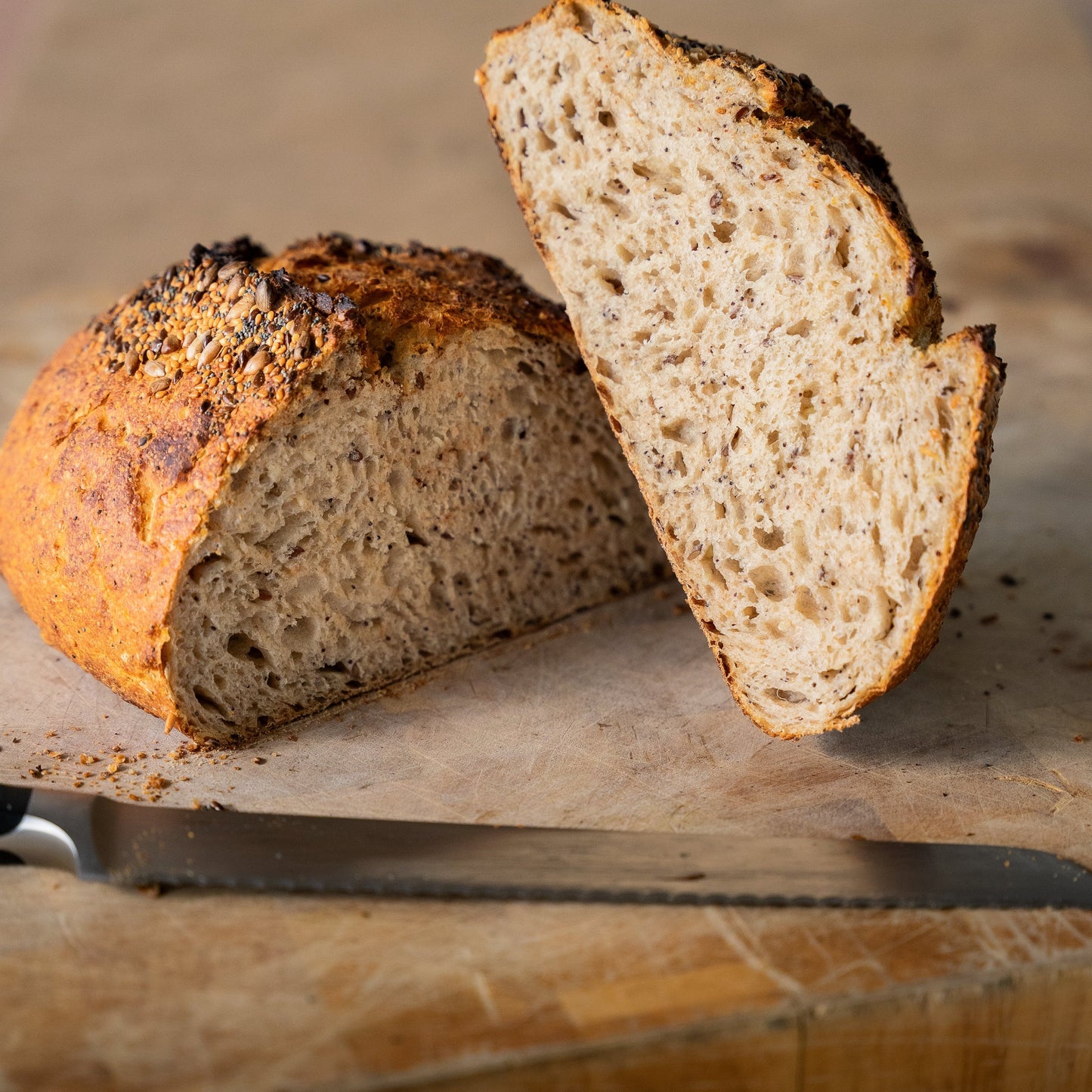 Sliced multigrain spelt bread with a crispy crust, enriched with flaxseeds, sunflower seeds, sesame seeds, and poppy seeds.
