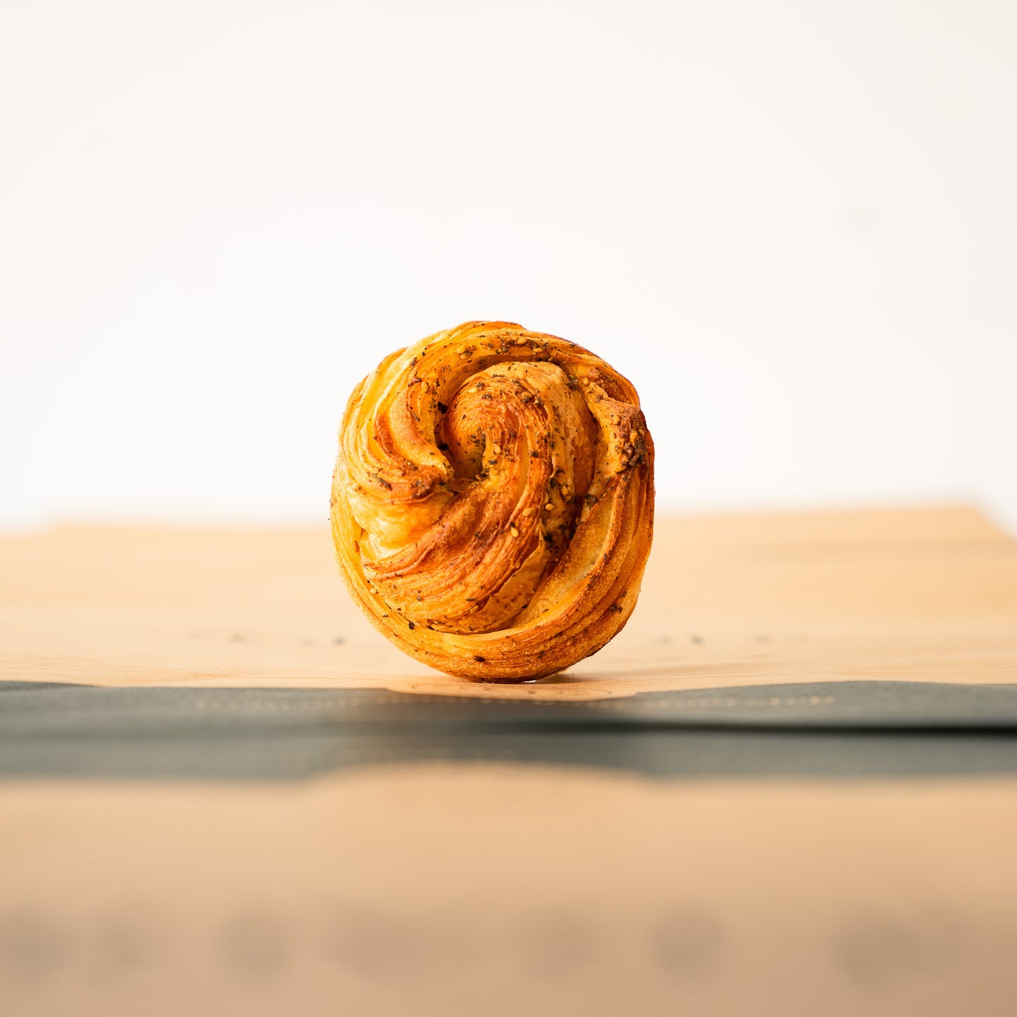 Close-up of a za’atar brioche, emphasizing its crisp layers and unique Middle Eastern flavor.