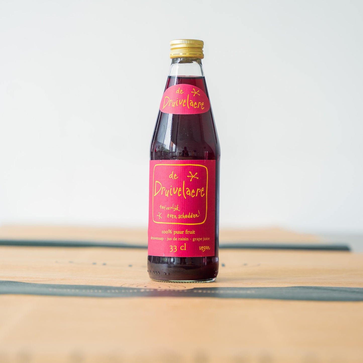 Druivelaere grape juice bottle with a vibrant red and gold label, filled with 100% pure grape juice for a fruity and refreshing taste