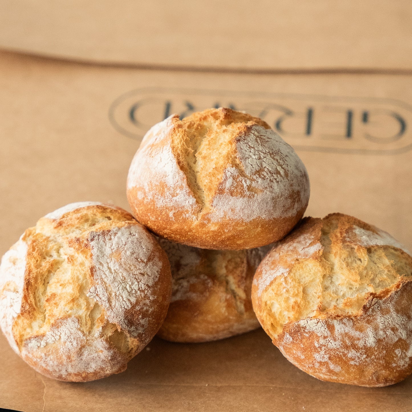 Four light and airy artisan bread rolls with a golden crust, perfect for breakfast or brunch.