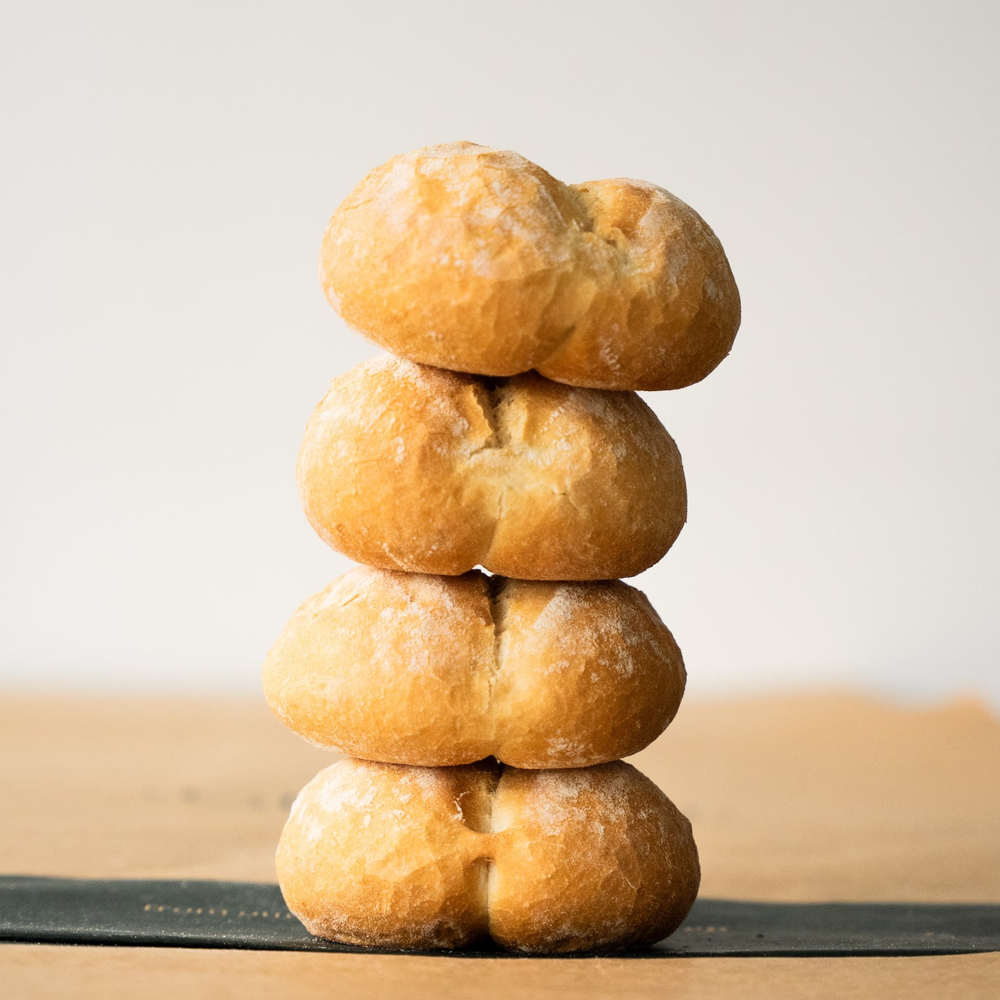 Stack of freshly baked pistolets, highlighting their golden crust and soft interior, perfect for a Belgian-style breakfast
