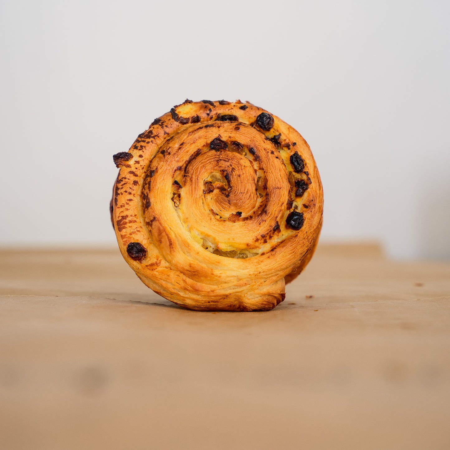 Swiss roll pastry made from croissant dough, featuring organic grapes, fermented for rich flavor and soft, crispy texture, crafted by Gérard Bakery's artisan baker.