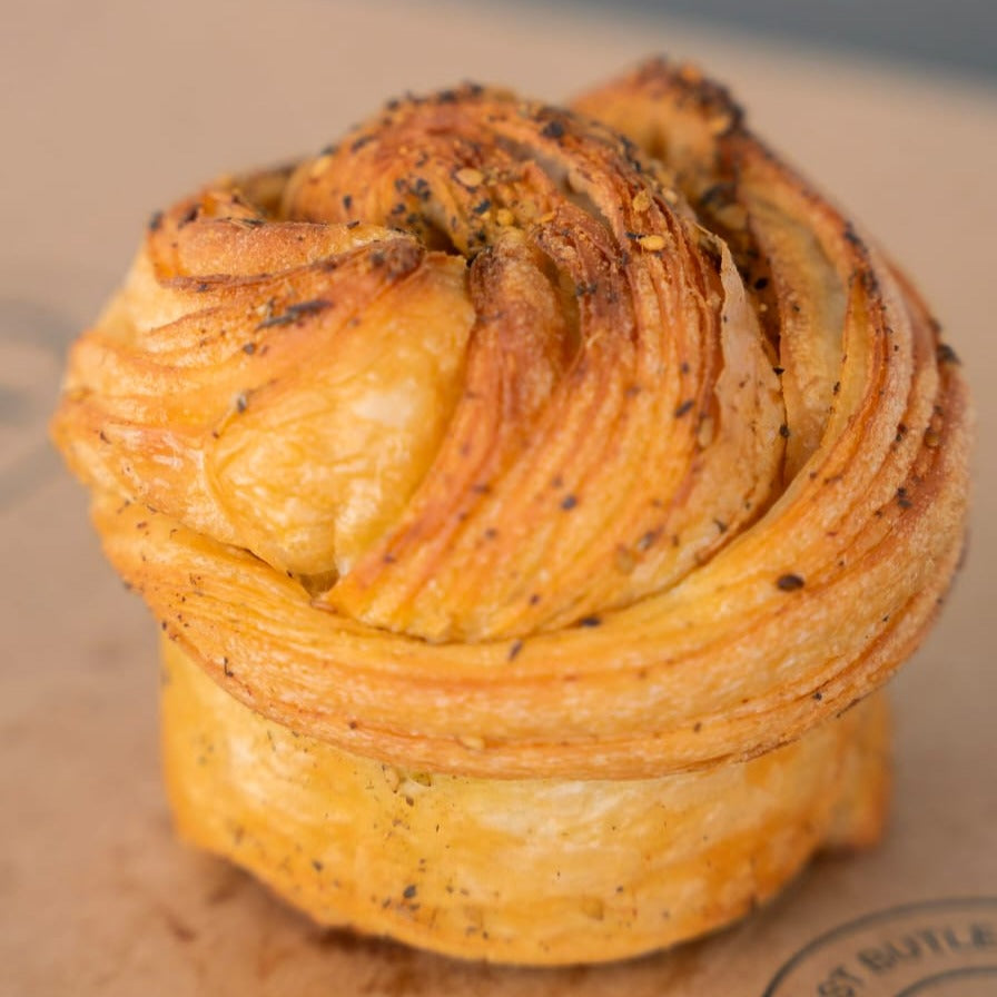Golden flaky brioche infused with Lebanese za’atar spice, showcasing its artisanal layers.