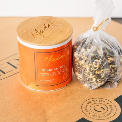 Madn White Tea Mix from the Digest Collection in a vibrant orange tin with a bamboo lid, offering a light and soothing tea blend for digestion support