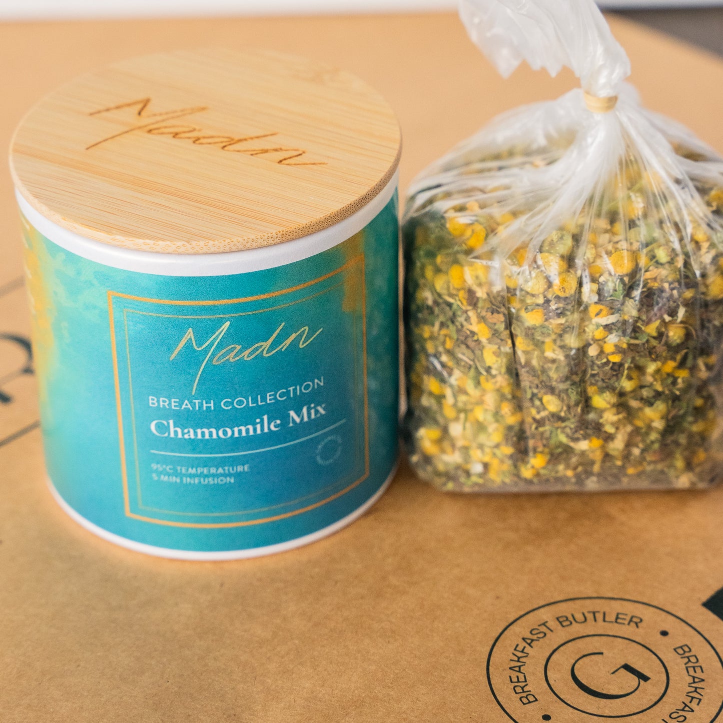 Madn Chamomile Mix from the Breath Collection in a serene blue-green tin with a bamboo lid, offering a calming and soothing herbal tea blend