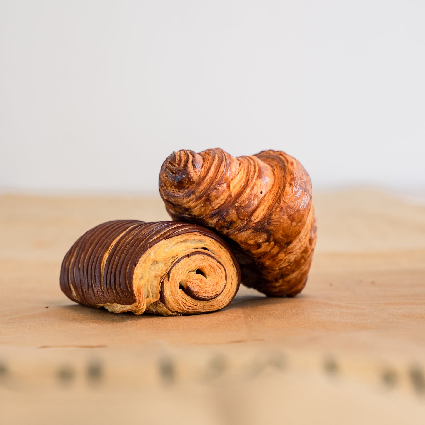 A perfectly baked croissant on top of a beautiful chocolate bread.