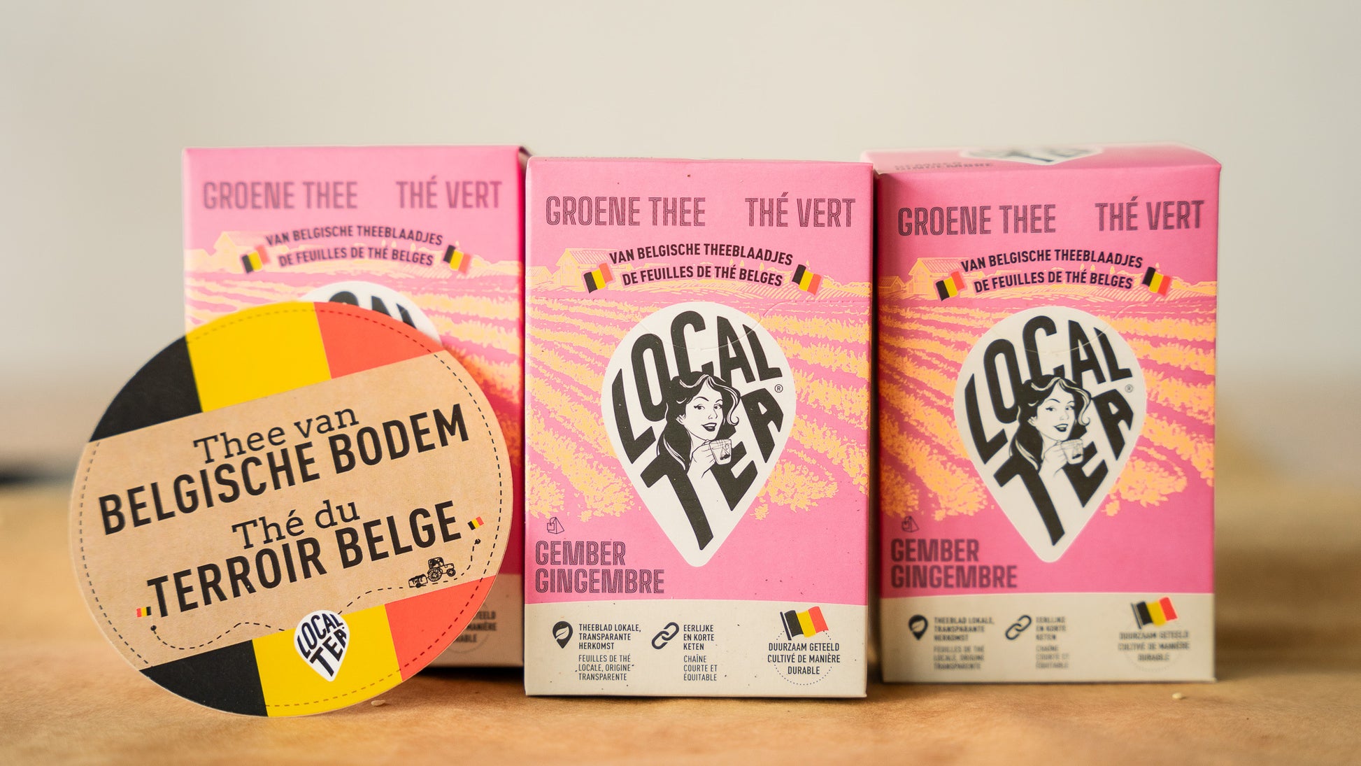 Three ginger-green tea packages placed next to each other with the writing "Tea from Belgian territory".