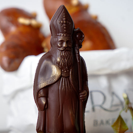 Dark chocolate figurine of Saint Nicholas covered with a touch of gold.