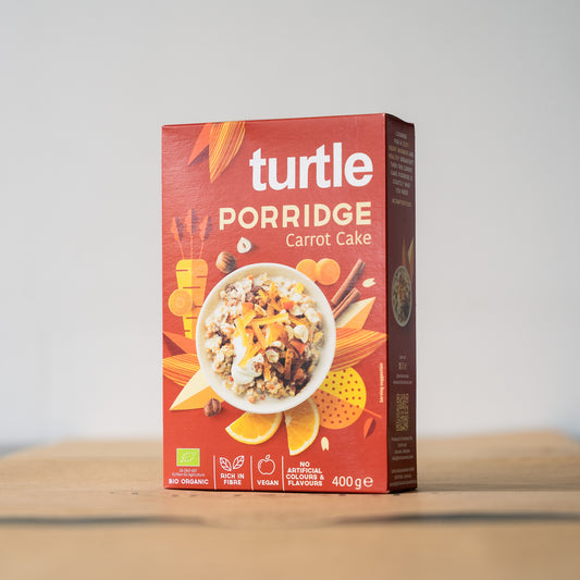 A box of Turtle Porridge, featuring organic oats, carrot pieces, and hazelnuts, perfect for a cozy breakfast experience.