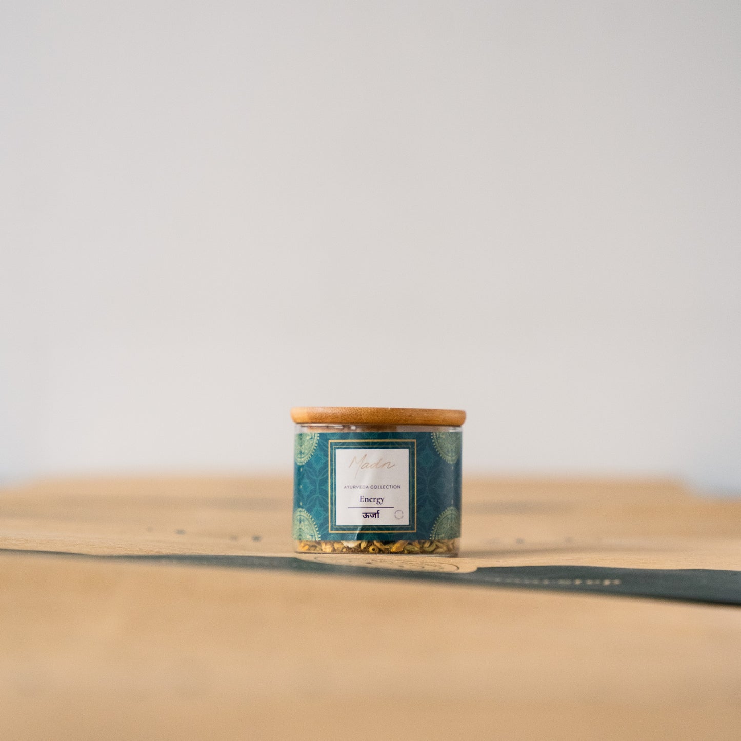 Madn Loose Leaf Tea from the Artisan Collection in a compact teal tin with a bamboo lid, showcasing a premium blend of carefully selected tea leaves.