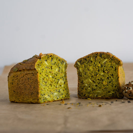Green pistachio flavored gluten free bread cut up in two.