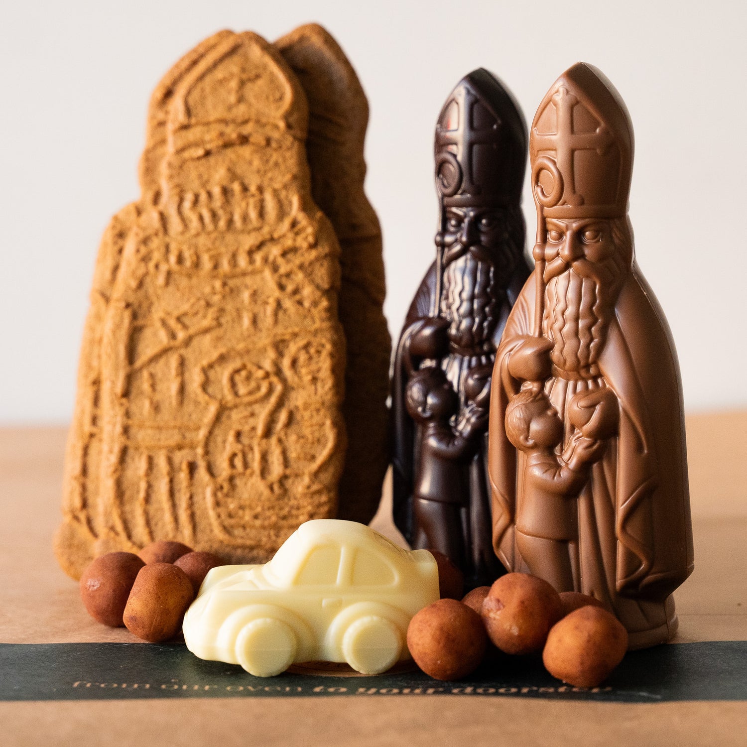 Saint Nicholas gift set featuring marzipan balls, speculoos biscuits, and chocolate figurines in dark, milk, and white varieties, perfect for festive celebrations.